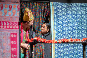 DJ James and Mrs. Krishnan chatting behind a beaded curtain