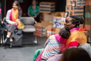 An audience member and her young child sitting together