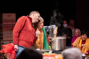 Two audience members cooking dahl and singing along