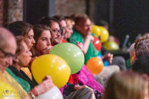 Audience members blowing up balloons