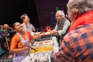 Mrs. Krishnan and DJ James serving Dahl to audience members