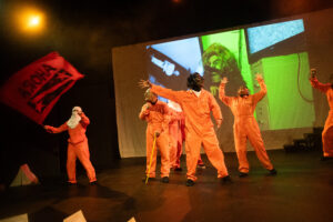 Clay figures in orange with their arms raised