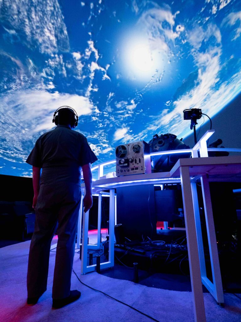 Person standing in front of projection of planet earth