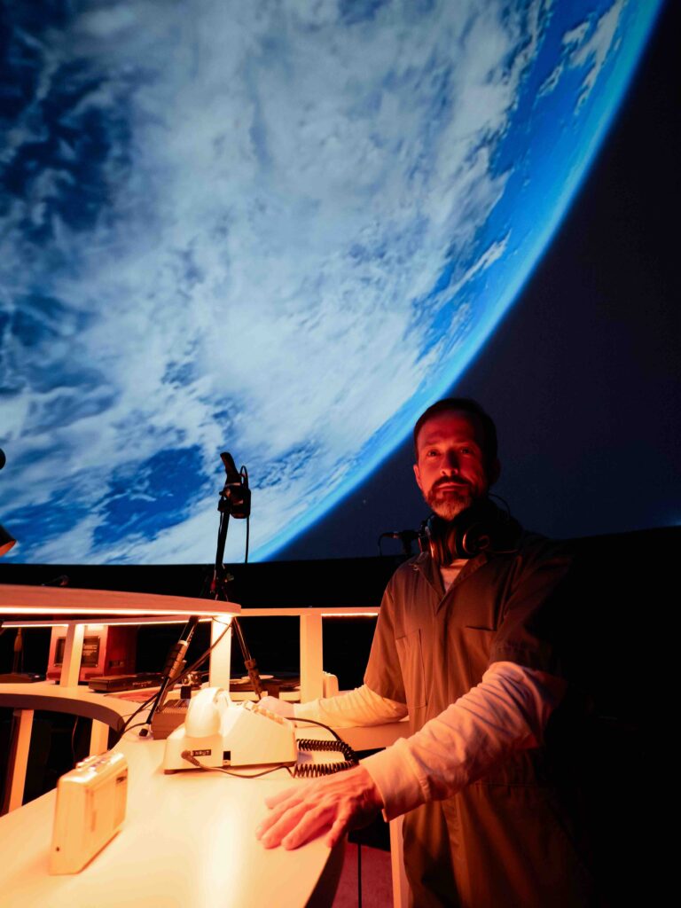 Person standing in front of projection of planet earth