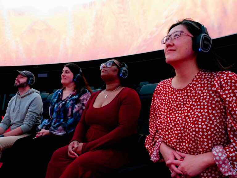 Audiences wearing headphones and enjoying the tech rehearsal