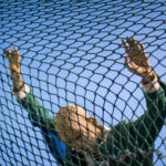 A puppet climbing a fence