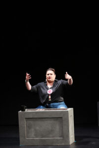 Murielle Borst-Tarrant standing on stage with her arms raised