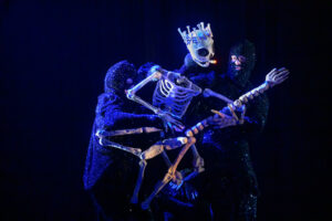 Bone king puppet playing guitar