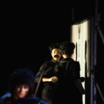 Actors talking to each other in front of a screen