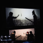 People acting out a scene where they are confronting each other doing shadow puppetry in front of the screen