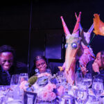 Life-sized puppets interacting with patrons at dinner