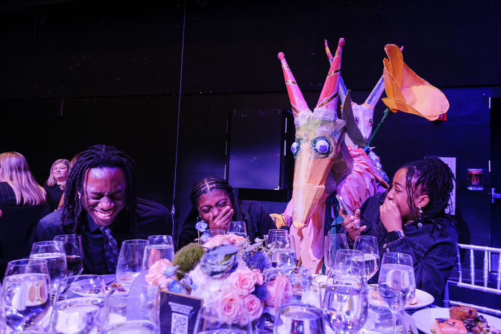 Life-sized puppets interacting with patrons at dinner