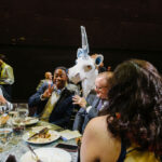 Life-sized puppets interacting with patrons at dinner