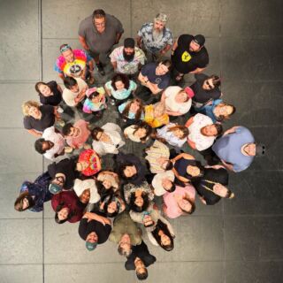 Hello from our staff!

Image description:Members of the ArtsEmerson staffing looking up at the ceiling for a photo. Photo is taken from a bird's eye view